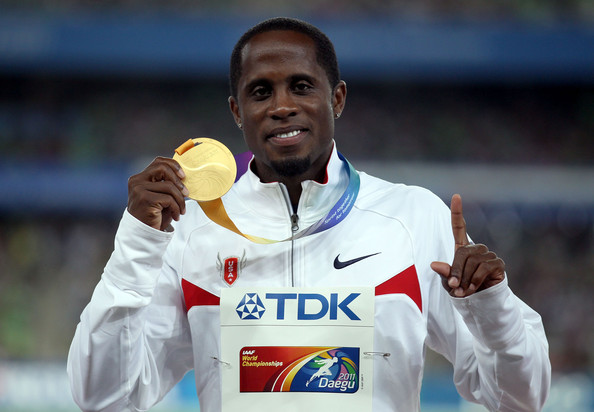 Olympic gold medalist Dwight Phillips holding up his world championship gold medal